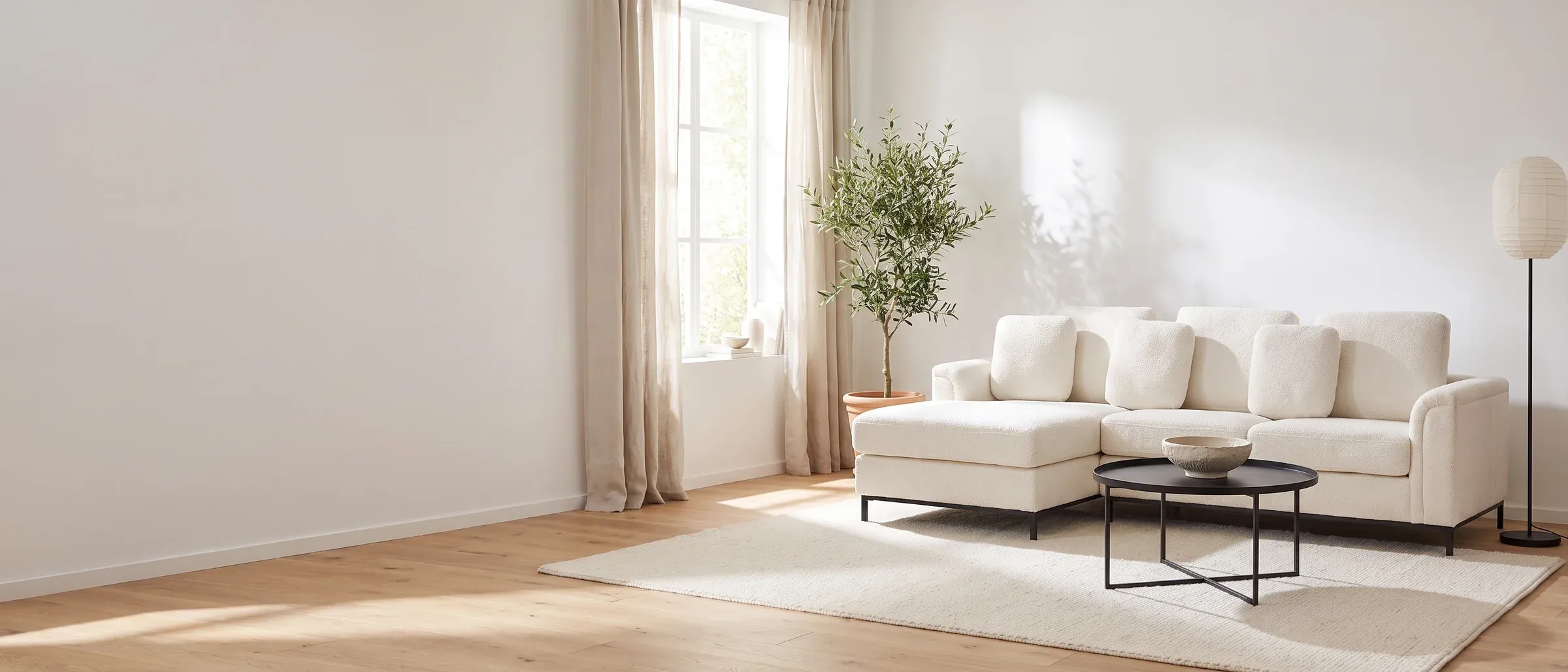 Offwhite hjørnesofa med sort salongbord i en hvit stue